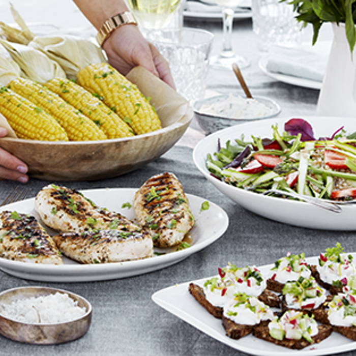 Kyllingebryst med krydderurter, asparges-salat, grillet majs med pisket smør samt grillet rugbrød med rygeostcreme og sprød agurke-topping